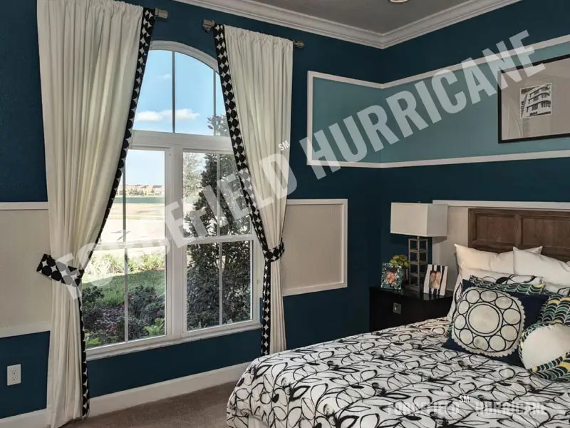 Bedroom with an arched impact window installed by Forcefield
